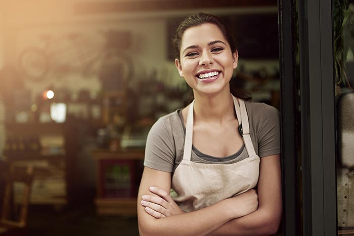 woman poses smiling in a doorframe