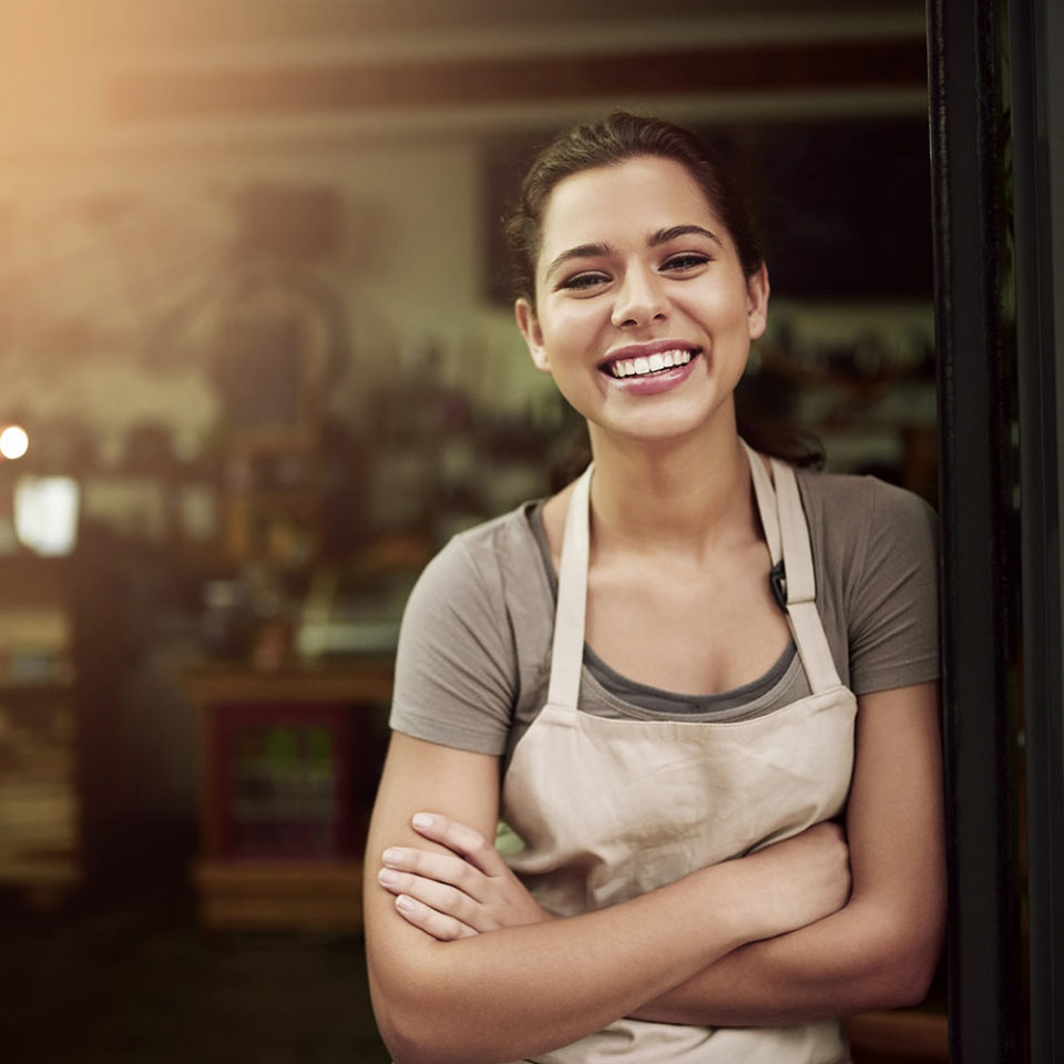 woman poses smiling in a doorframe