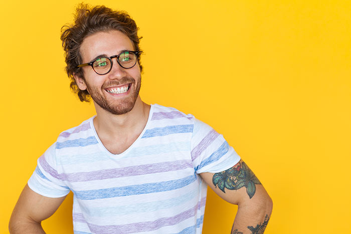 smiling man in front of yellow background